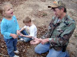 A father teaching his children to hunt for arrowheads.